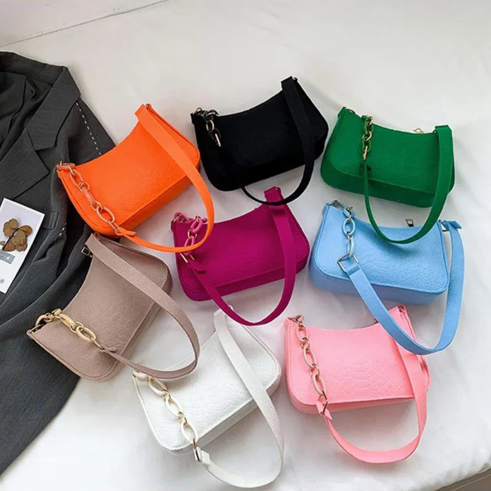 Fashionable women's small handle underarm bags in solid colors with chain design, displayed in various vibrant shades.