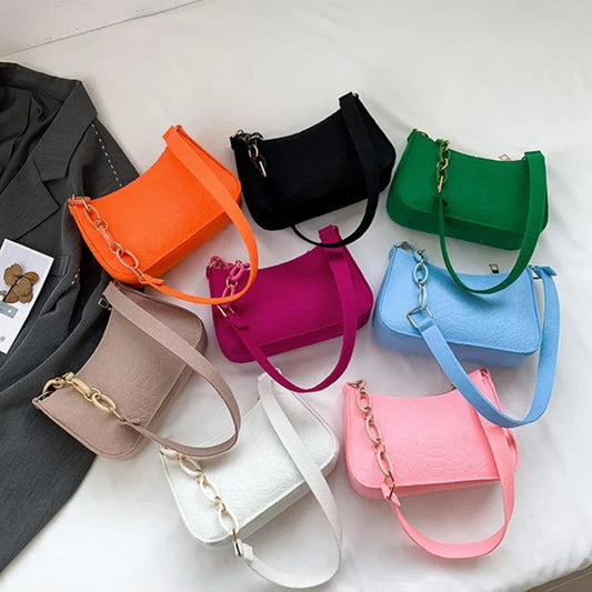 Fashionable women's small handle underarm bags in solid colors with chain design, displayed in various vibrant shades.